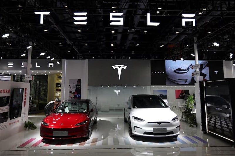 A staff member looks at Tesla's new Model 3 sedan displayed next to Model X SUV at the China International Fair for Trade in Services (CIFTIS) in Beijing, China September 2, 2023. PHOTO: REUTERS